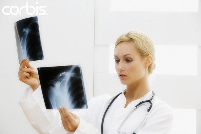 Doctor Looking at X-Rays --- Image by © Thomas Roepke/Corbis
