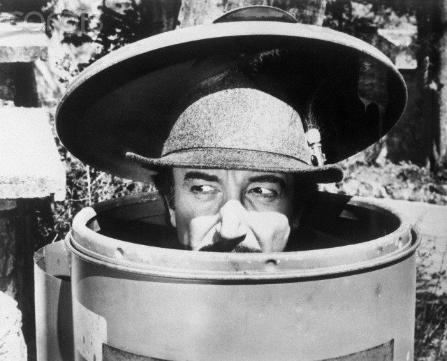 01 Jan 1976, London, England, UK --- Inspector Jacques Clouseau (Peter Sellers) hides in a trash can in The Pink Panther Strikes Again. --- Image by © Bettmann/CORBIS