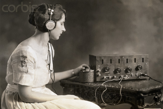 Washington, DC, USA --- Evelyn C. Lewis, Miss Washington 1921, listens to the radio. She tunes in by adjusting the condenser. --- Image by © Corbis